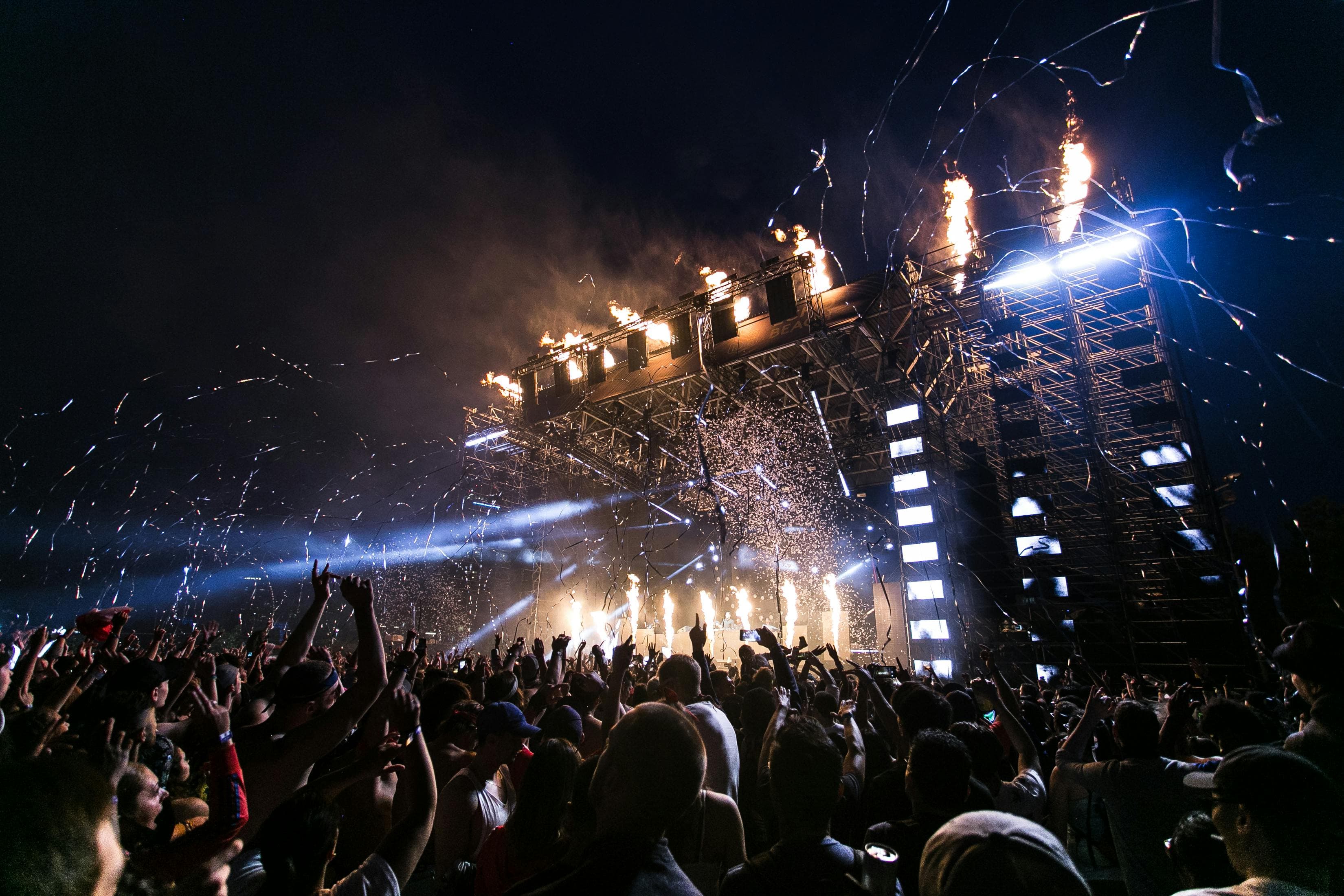 Friends and festivalgoers celebrating together at a nighttime performance